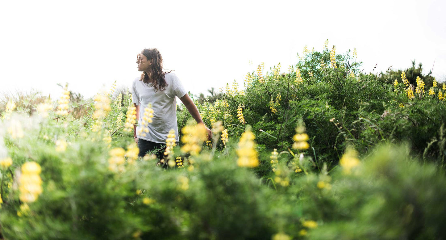 young man walking through summer meadow